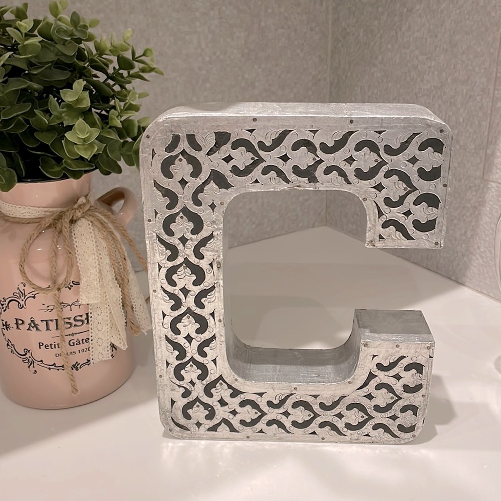 Decorative letter “C”.